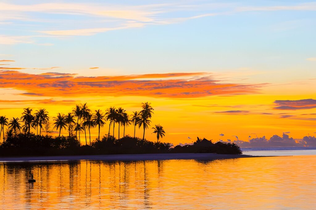 Couple enjoying a sunset cruise with golden skies over lagoon